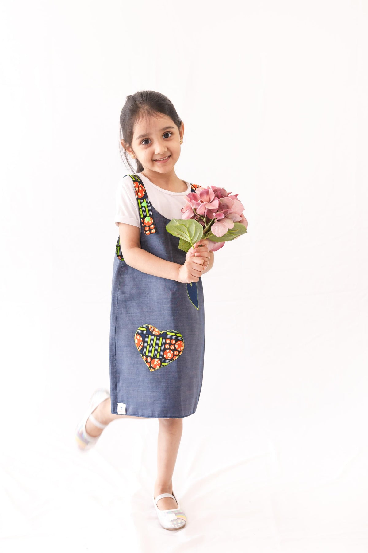 reversible pinafore features denim on one side and a wonderful orange and bright green wax print on the other reverse